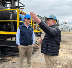 Congressman Moran with tour guide pointing out the roles of machinery